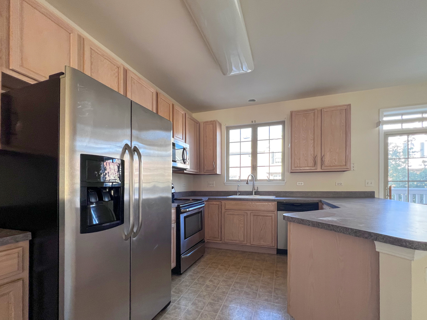 554 Prestwick Lane, Unit 554 Wheeling, IL 60090 - Photo 9 of 30 a kitchen with stainless steel appliances granite countertop a refrigerator a sink a stove and island