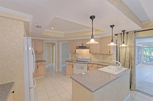 a kitchen that has a lot of white cabinets and stainless steel appliances