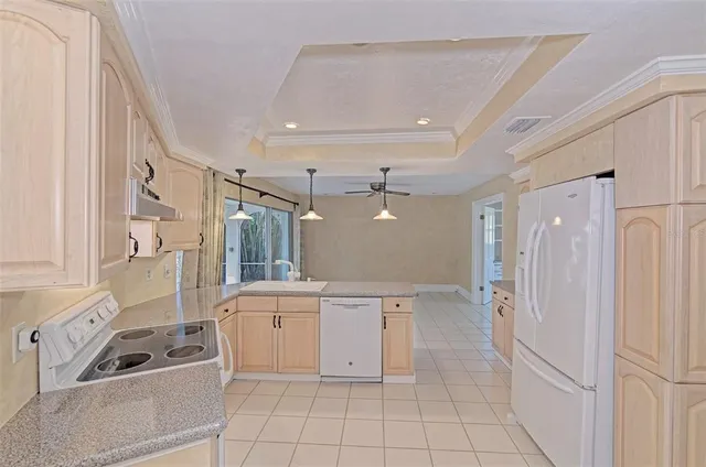 a kitchen with white cabinets and refrigerator