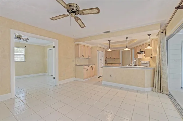a view of a kitchen with refrigerator and white cabinets