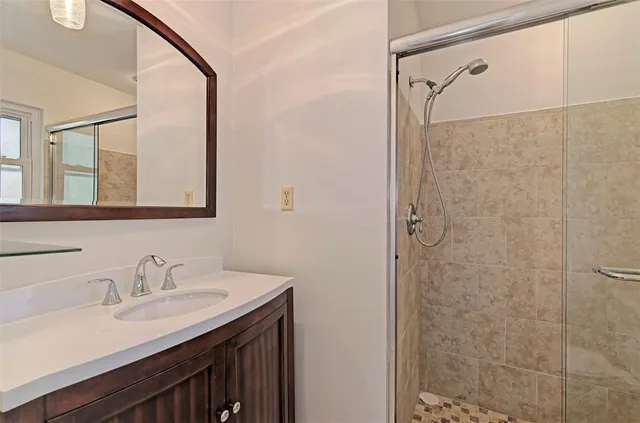 a bathroom with a granite countertop sink a shower and a mirror