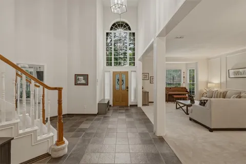 a living room with furniture chandelier and a window