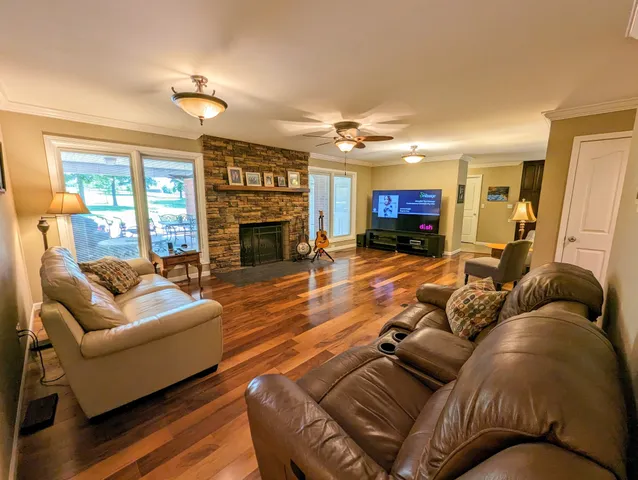 a living room with furniture fireplace and a large window