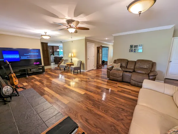 a living room with furniture a flat screen tv and a window
