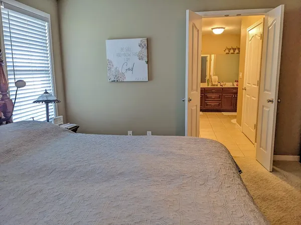 a bedroom with a bed and a painting on the wall