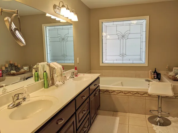 a bathroom with a tub sink and mirror