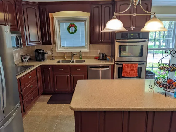 a kitchen with stainless steel appliances a stove a sink dishwasher and cabinets with wooden floor