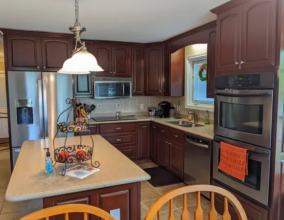 a kitchen with stainless steel appliances granite countertop a stove a sink a microwave dining table and chairs