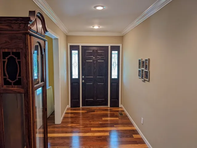 a view of a hallway with wooden floor and entryway