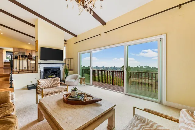 a kitchen with stainless steel appliances kitchen island granite countertop a refrigerator a sink and white cabinets next to a large window