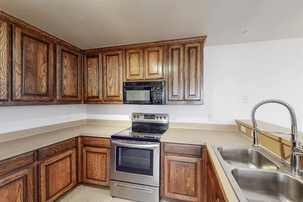 a kitchen with granite countertop a sink stainless steel appliances and cabinets