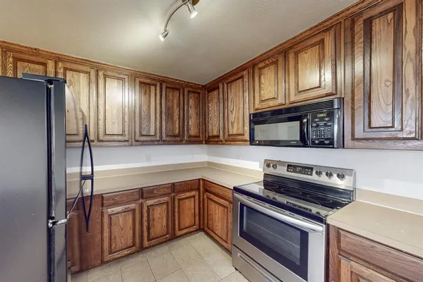 a kitchen with stainless steel appliances granite countertop wooden cabinets a stove top oven a sink and dishwasher
