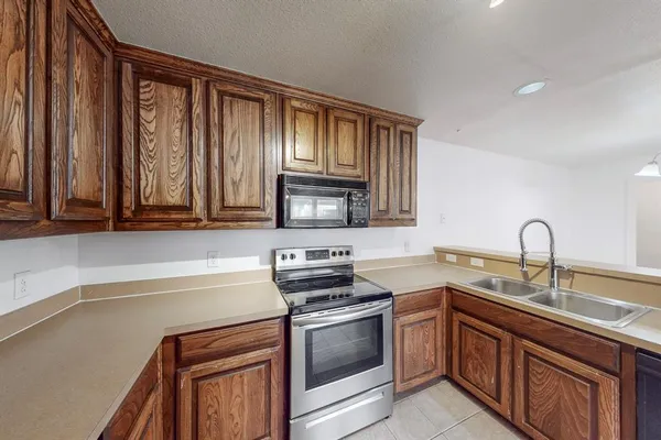a kitchen with stainless steel appliances granite countertop a sink stove and microwave
