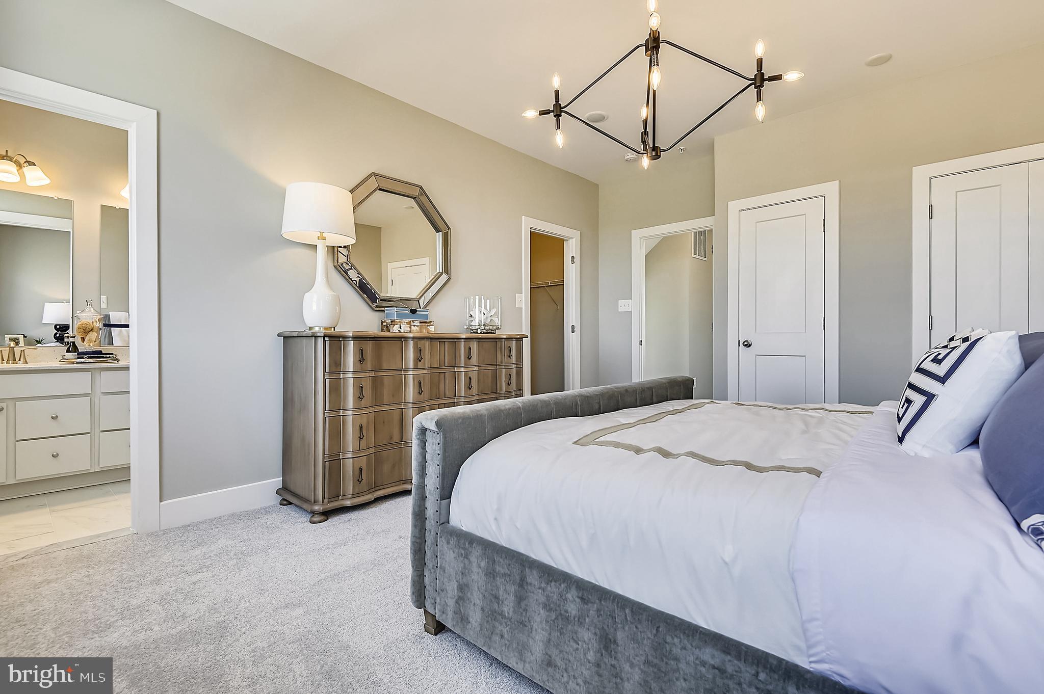 16605 Breezeway Alley Accokeek, MD 20607 - Photo 29 of 34 a bedroom with a bed a chandelier with a dresser