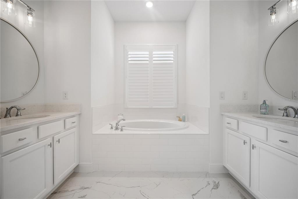 17588 Lake Star Road Winter Garden, FL 34787 - Photo 22 of 57 a bathroom with a bathtub sink vanity and mirror