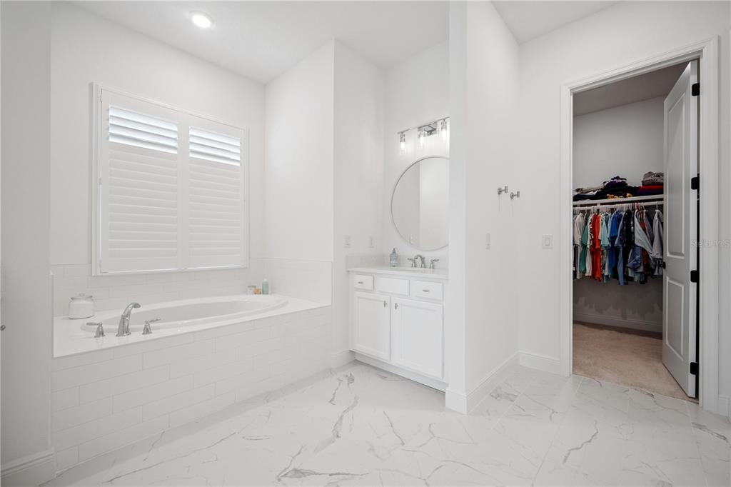 17588 Lake Star Road Winter Garden, FL 34787 - Photo 23 of 57 a bathroom with a bathtub sink and mirror