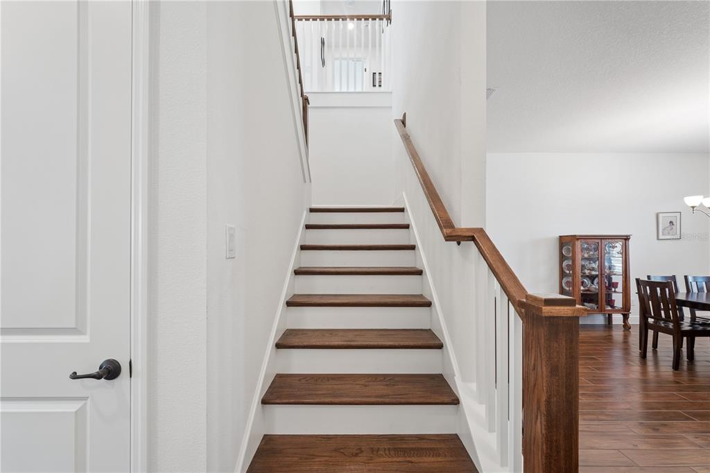 17588 Lake Star Road Winter Garden, FL 34787 - Photo 29 of 57 a view of staircase with lots of frames on wall and wooden floor