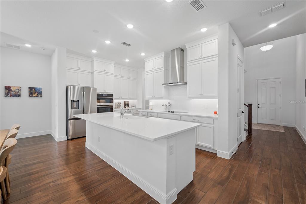 17588 Lake Star Road Winter Garden, FL 34787 - Photo 3 of 57 a large kitchen with stainless steel appliances kitchen island a large counter top and a refrigerator