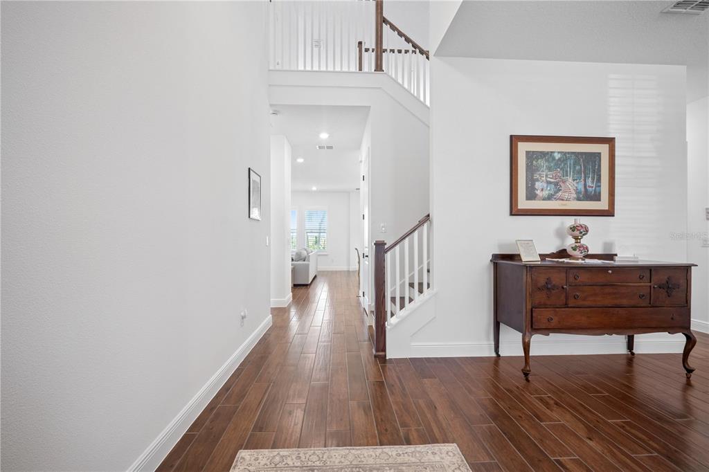17588 Lake Star Road Winter Garden, FL 34787 - Photo 8 of 57 a view of a hallway with wooden floor and a chandelier