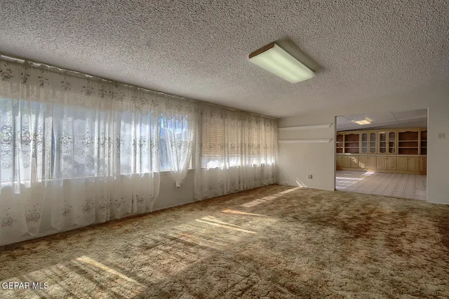 a view of a room with a chandelier fan and closet area