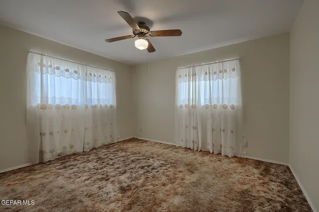 a view of a big room with wooden floor and a ceiling fan