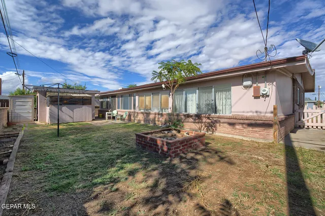 a backyard of a house with table and chairs