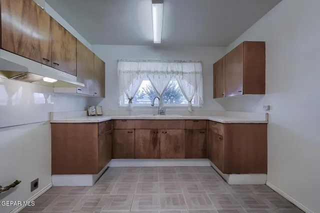 a kitchen with a sink a cabinets and window