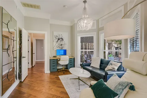a living room with furniture chandelier and a table