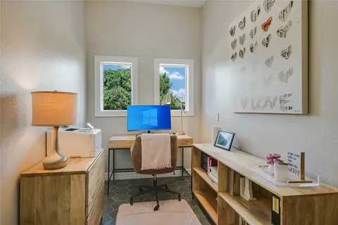 a view of a workspace with furniture and a window