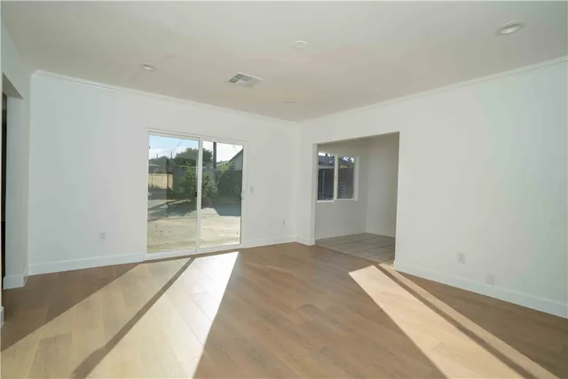a view of a room with wooden floor and front door