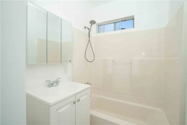a bathroom with a shower sink and vanity