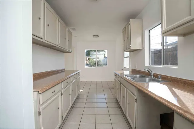 a kitchen with granite countertop a sink stove and cabinets