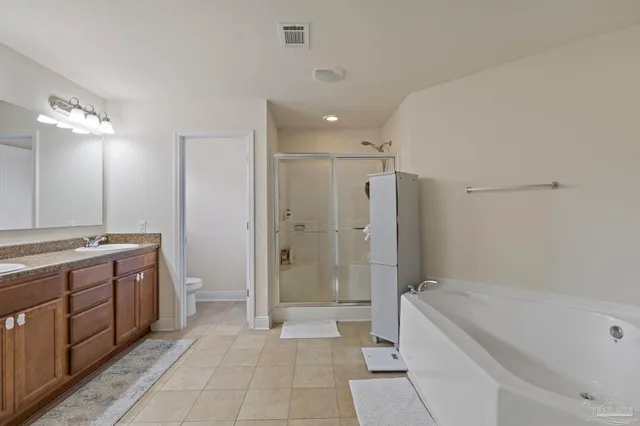 a bathroom with a granite countertop sink a toilet a mirror and bathtub
