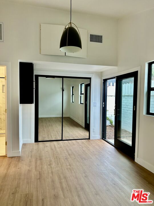 17209 Keswick Street Lake Balboa, CA 91406 - Photo 8 of 19 a view of an empty room with wooden floor and a hallway