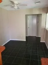 en empty room with wooden floor and fan