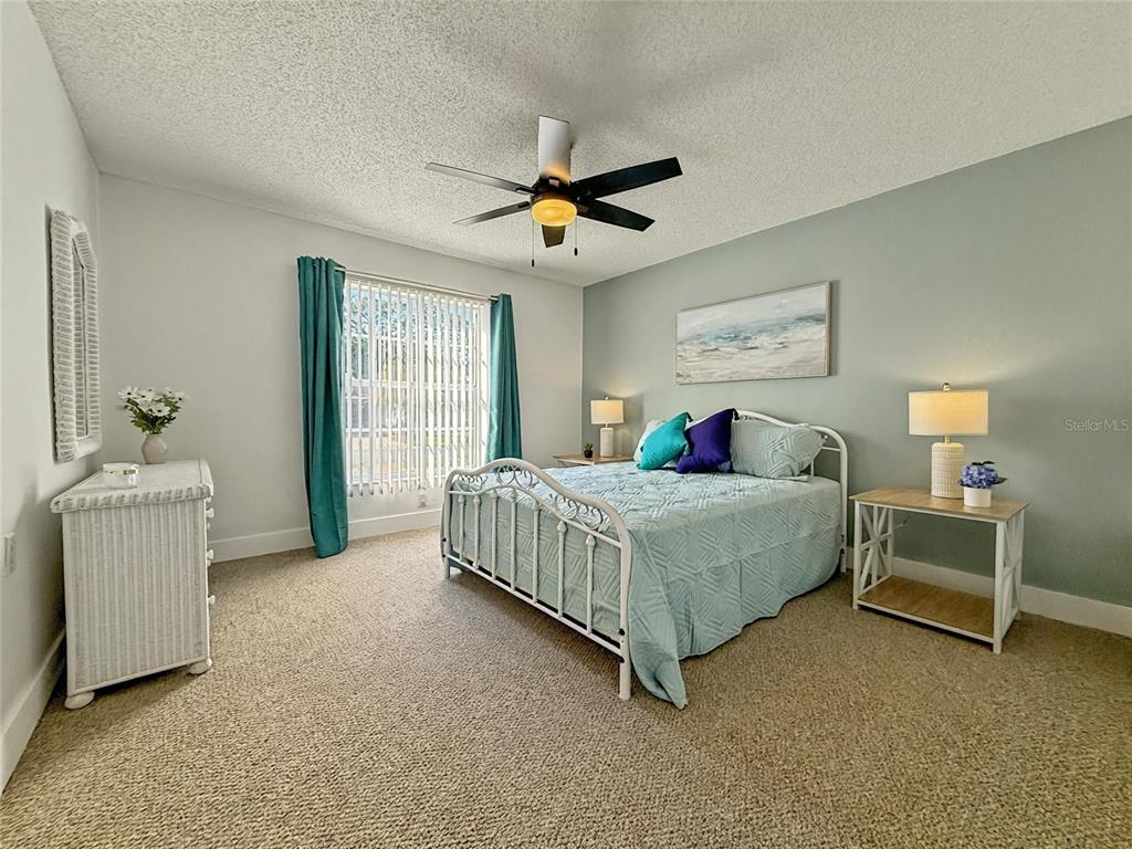 2436 Deer Trail Lane Spring Hill, FL 34606 - Photo 18 of 56 a bedroom with a bed and a chandelier