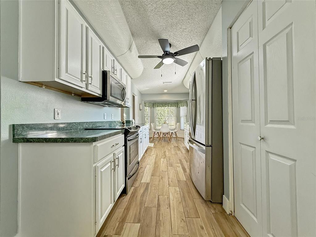 2436 Deer Trail Lane Spring Hill, FL 34606 - Photo 10 of 56 a kitchen with stainless steel appliances granite countertop a sink and wooden floor