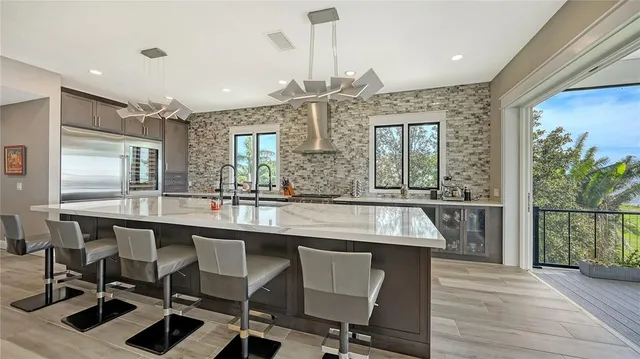 a dining hall with stainless steel appliances granite countertop a kitchen island a stove and a wooden floors