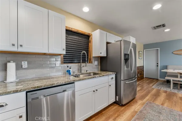 a kitchen with a refrigerator sink and cabinets