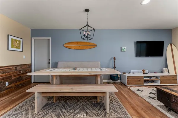 a living room with furniture a flat screen tv and kitchen view
