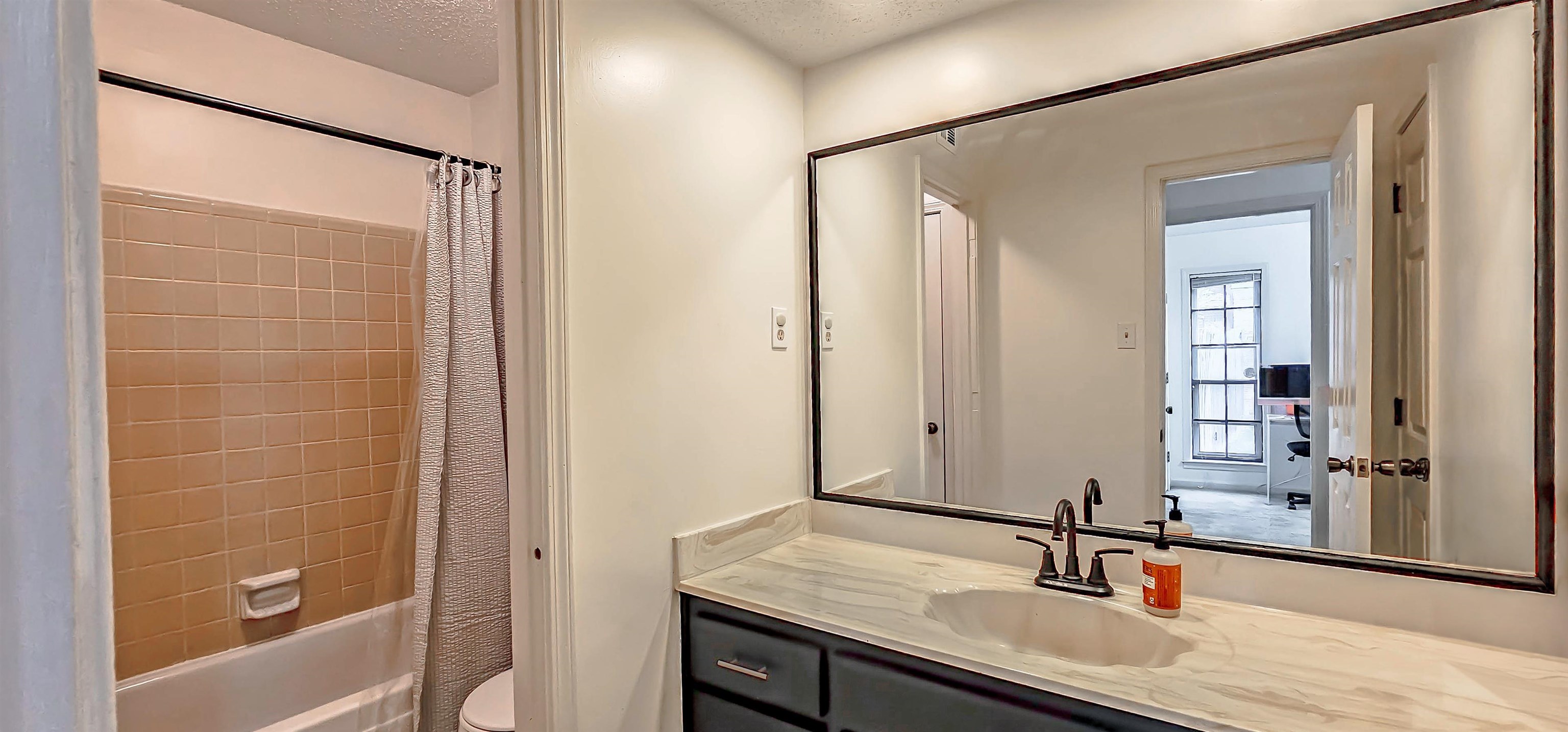 3204 Ruskin Road Memphis, TN 38134 - Photo 19 of 24 a bathroom with a granite countertop sink mirror and a bathtub