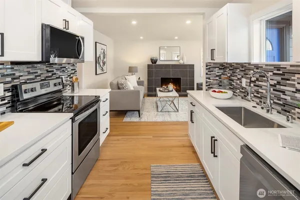 a kitchen with stainless steel appliances a stove top oven a sink dishwasher and a microwave