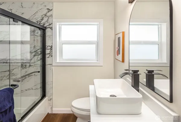 a bathroom with a granite countertop sink toilet and shower