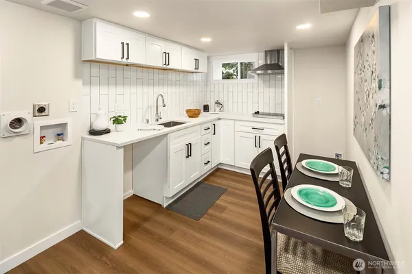 a kitchen with a sink a stove and wooden floor