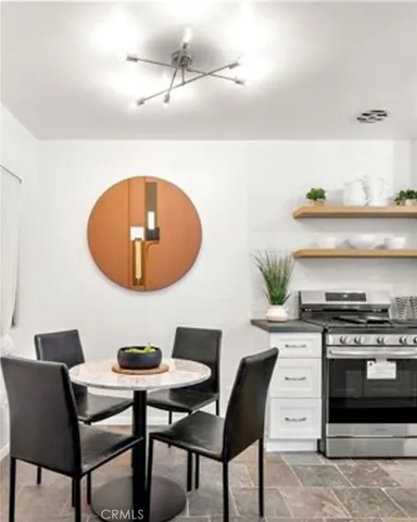 a kitchen with a stove a table and chair