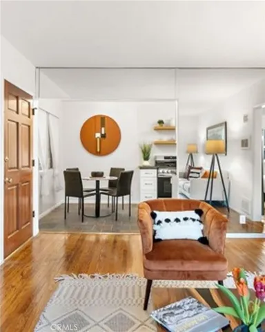 a living room with chairs and wooden floor