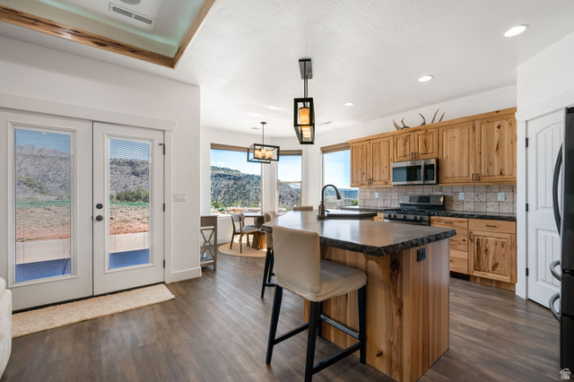 62 North Lucky 7 Road Veyo, UT 84782 - Photo 11 of 43 Kitchen with dark countertops, a center island with sink, french doors, and a breakfast bar