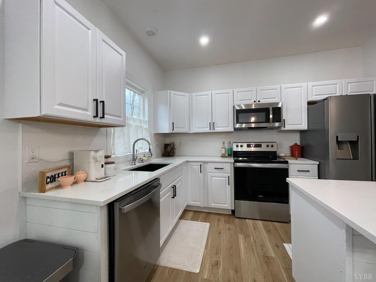708 Grove Street Bedford, VA 24523 - Photo 12 of 22 a kitchen with stainless steel appliances a sink a stove a microwave a refrigerator a sink and cabinets