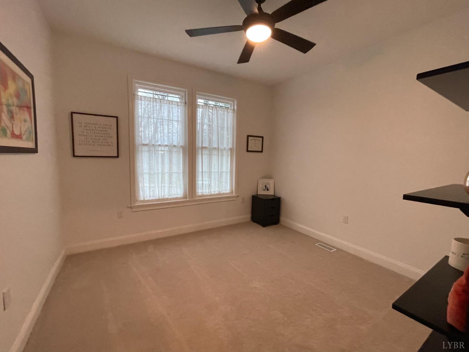 708 Grove Street Bedford, VA 24523 - Photo 3 of 22 an empty room with windows and fan