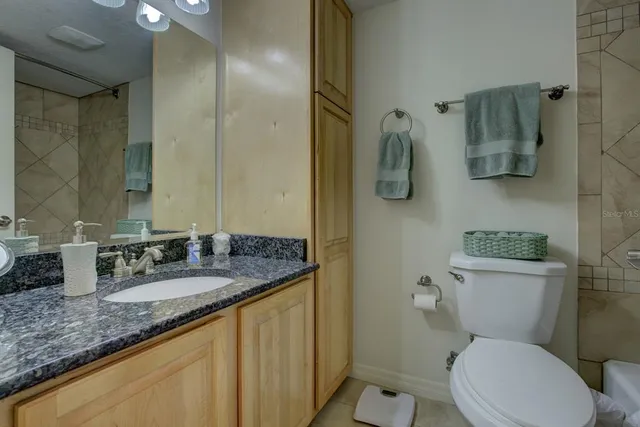 a bathroom with a granite countertop sink toilet and shower